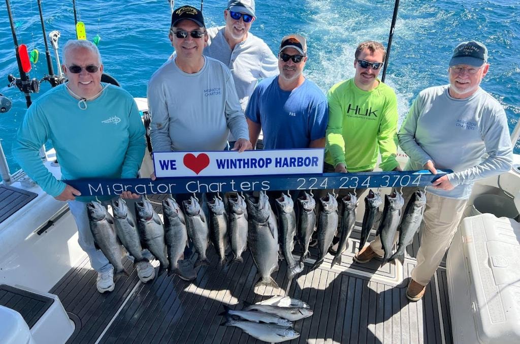 Angler holding a large Lake Michigan salmon on a Migrator Charters boat out of Winthrop Harbor